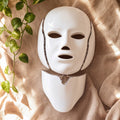 NeoTelle Spectra LED face mask and neck plate on warm beige cloth